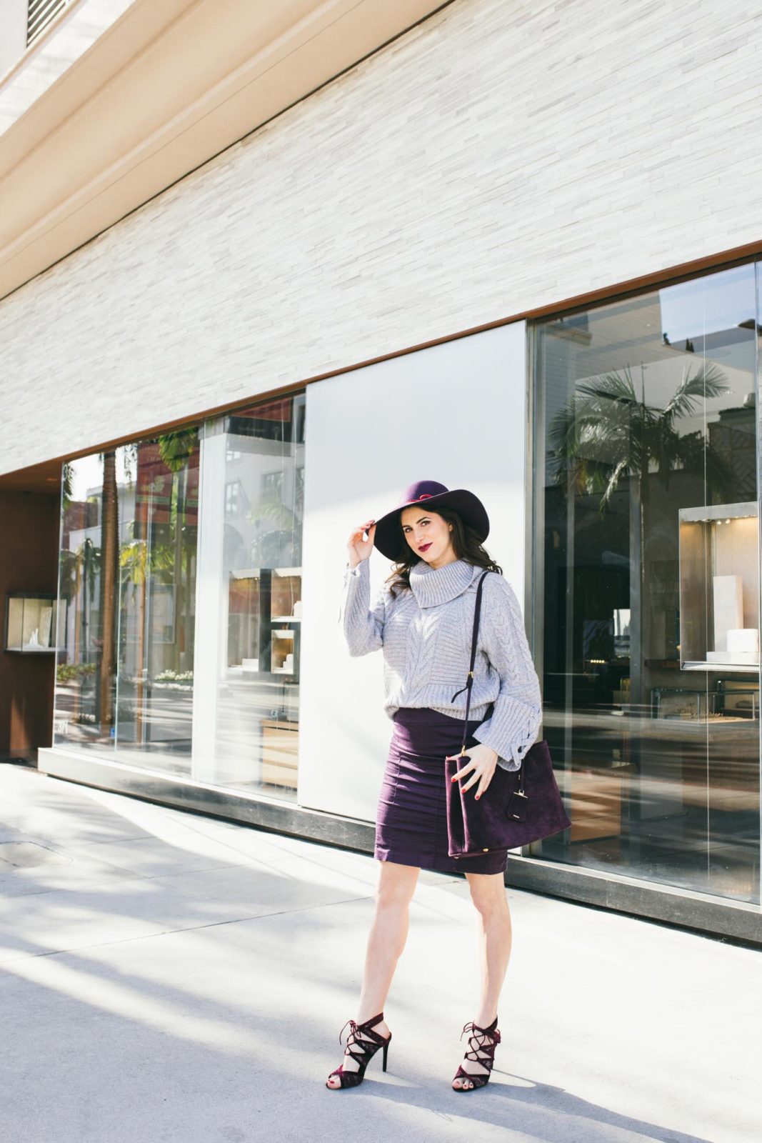 Spring Work Outfits featured by top US fashion blogger Laura Lily; Image of a woman wearing Bell Sleeve Sweaters and Purple suede Prada bag.