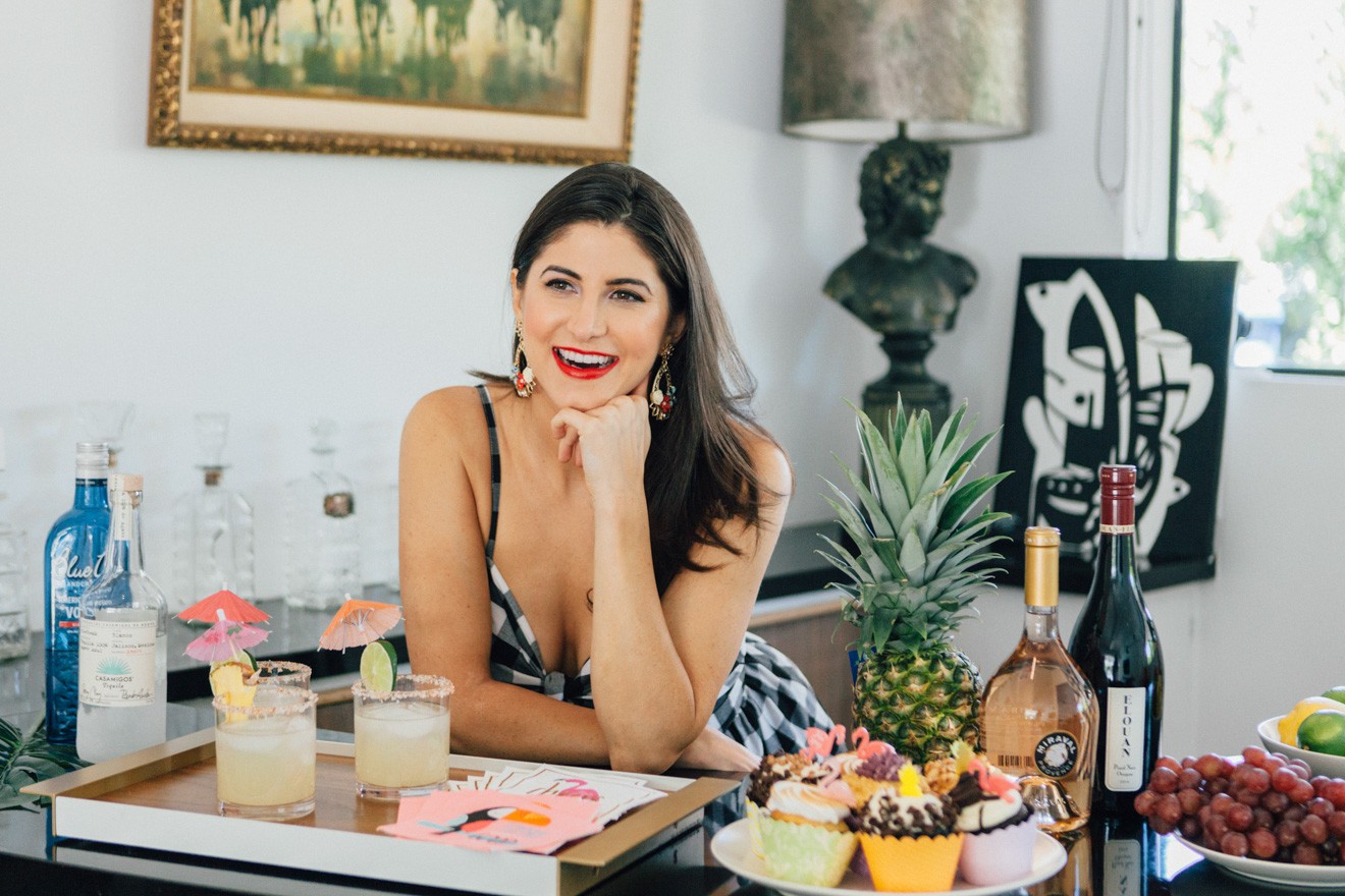10 Party Hosting Tips Every Hostess Should Know by Lifestyle Blogger Laura Lily | Dinner Party Essentials: Hosting Tips, Table Settings Ideas and Bar Cart Inspiration by popular Los Angeles life and style blogger, Laura Lily: image of a woman leaning on her elbow next to a tray of drinks and a platter of cupcakes. 
