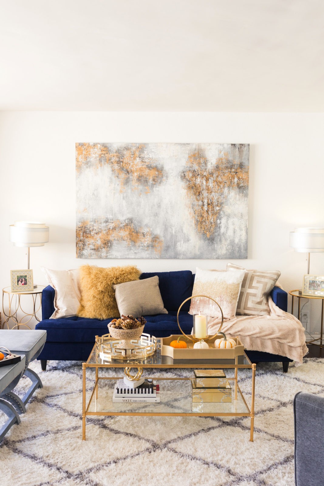 Z Gallerie Fall Decor Ideas by Popular Lifestyle Blogger Laura Lily | Dinner Party Essentials: Hosting Tips, Table Settings Ideas and Bar Cart Inspiration by popular Los Angeles life and style blogger, Laura Lily: image of a living room with a blue velvet couch, gold glass top coffee table, cream and gold throw pillows, and a white shag rug. 