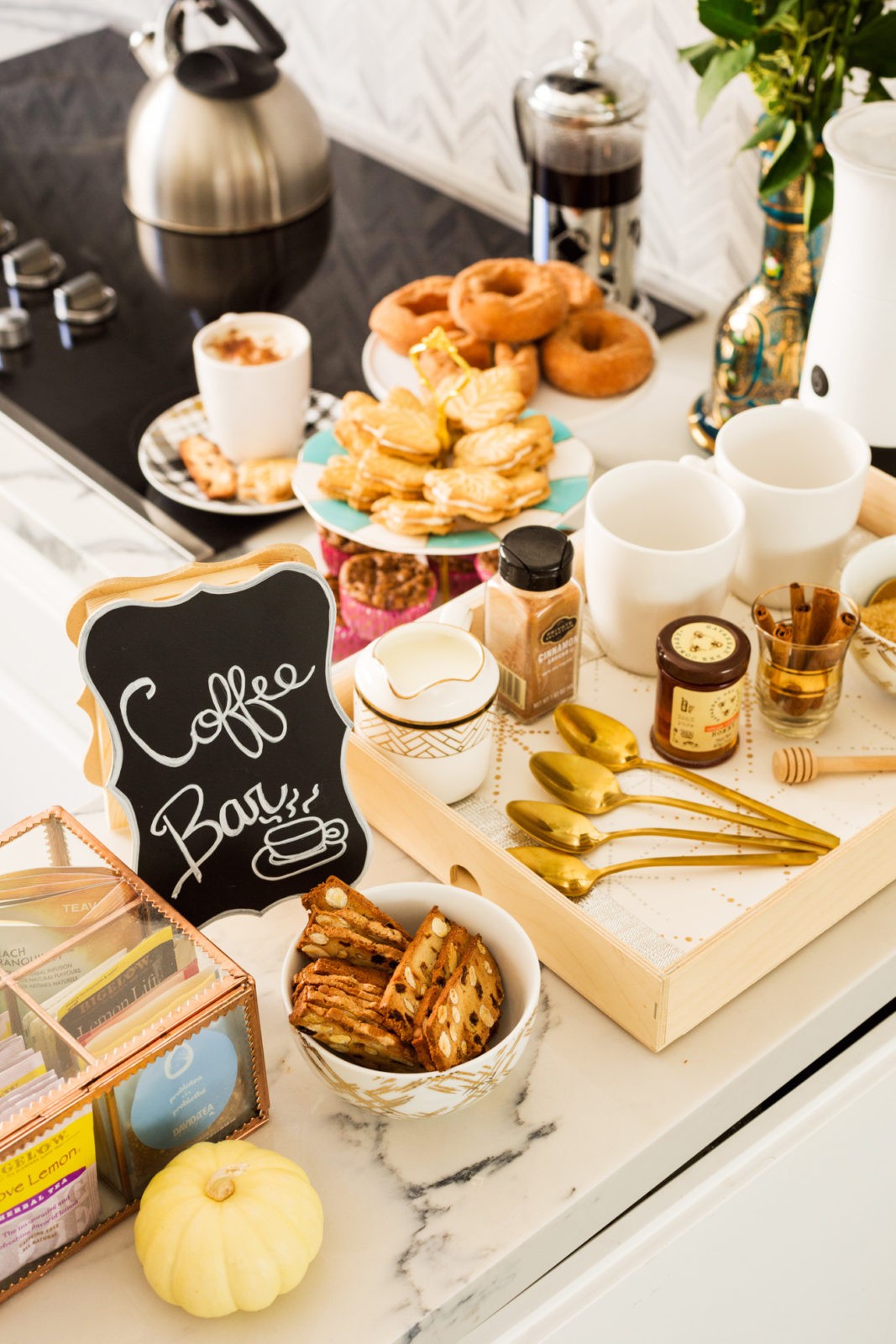 Festive Coffee Bar ideas by Popular Lifestyle Blogger Laura Lily | Dinner Party Essentials: Hosting Tips, Table Settings Ideas and Bar Cart Inspiration by popular Los Angeles life and style blogger, Laura Lily: image of a coffee bar with cookies, biscotti, donuts, coffee mugs, and coffee packets. 