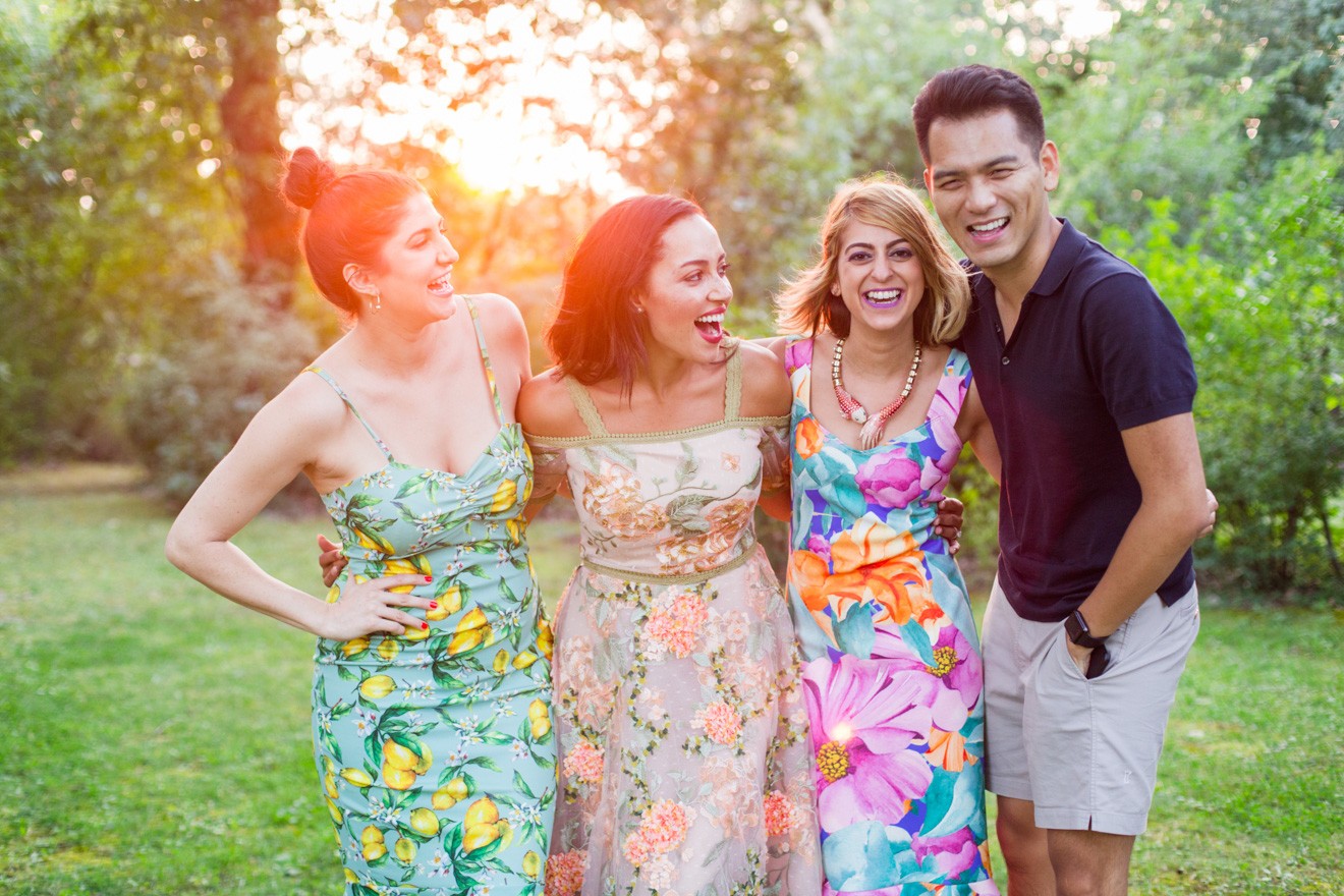 Summer Picnic in Italy by Lifestyle Blogger Laura Lily, I Am Fashion Laine, Elizabeth Keene | An Italian Picnic by popular US fashion blogger, Laura Lilly: image of 3 women in garden dresses and one man in a polo shirt and khaki shorts standing together with their arms around each other at La Foce Property in Tuscany, Italy.