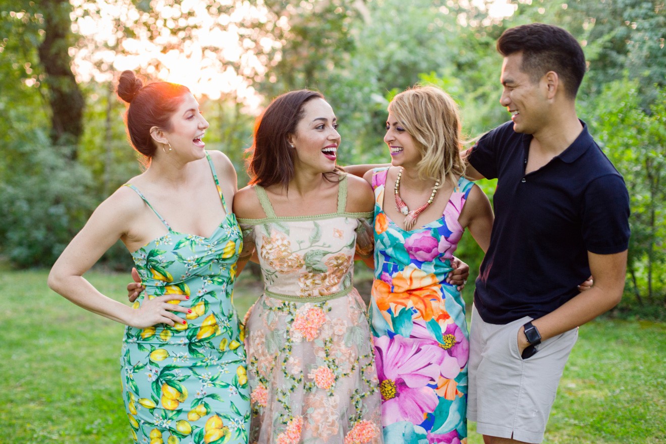 Summer Picnic in Italy by Lifestyle Blogger Laura Lily, I Am Fashion Laine, Elizabeth Keene | Summer Picnic in Italy by Lifestyle Blogger Laura Lily, I Am Fashion Laine, Elizabeth Keene, | An Italian Picnic by popular US fashion blogger, Laura Lilly: image of 3 women in garden dresses and one man in a polo shirt and khaki shorts standing together with their arms around each other at La Foce Property in Tuscany, Italy.