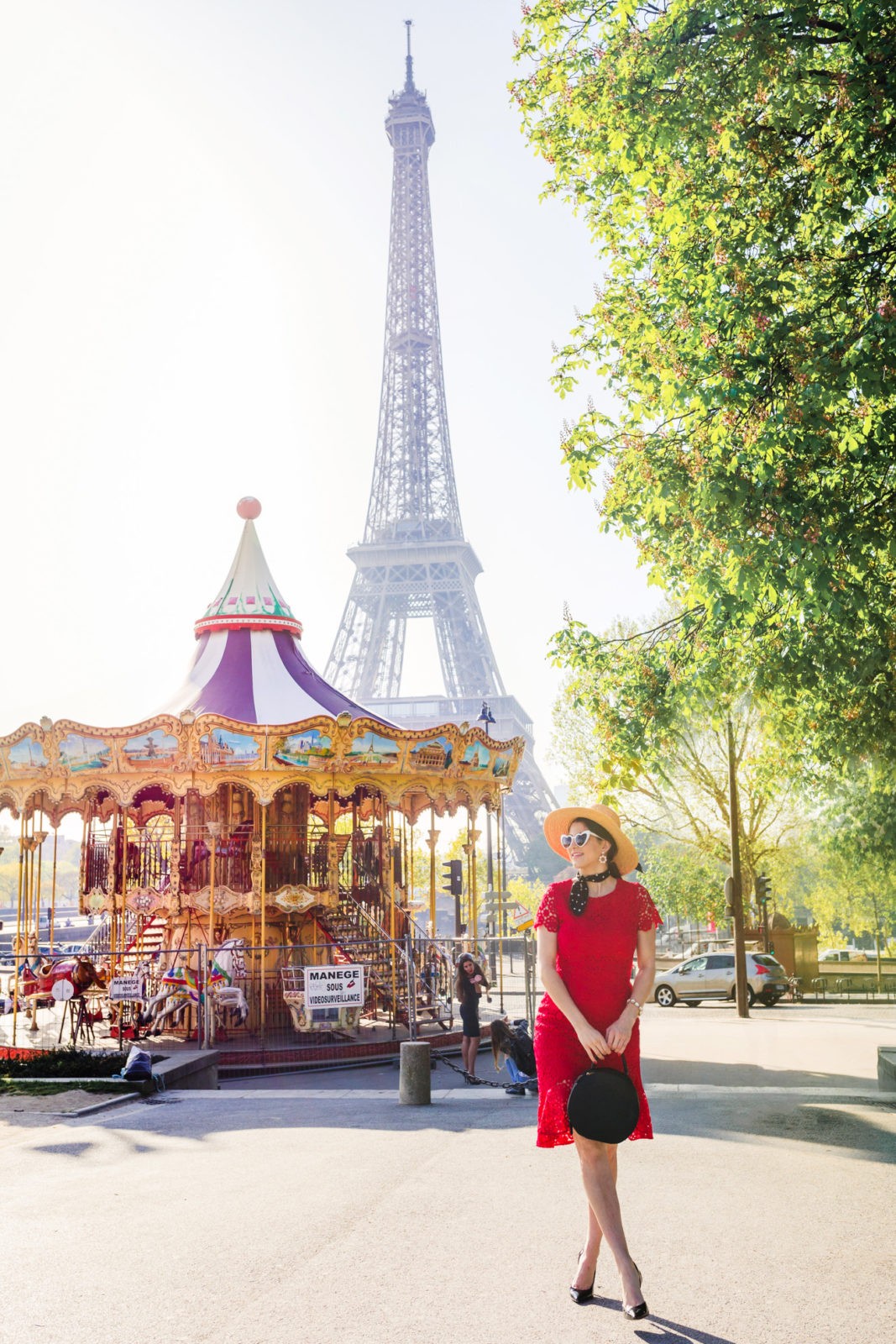 The Importance of Self Love by Fashion Blogger Laura Lily, Red Lace Eliza J Dress | How to Take Good Travel Photos by popular California travel blogger, Laura Lily: image of woman standing in front of the Merry-go-Round at Tocadero Park in Paris, France.