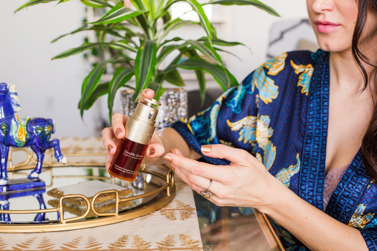 Clarins Double Serum featured by top US fashion blogger Laura Lily; Image of a woman wearing a blue silk robe.