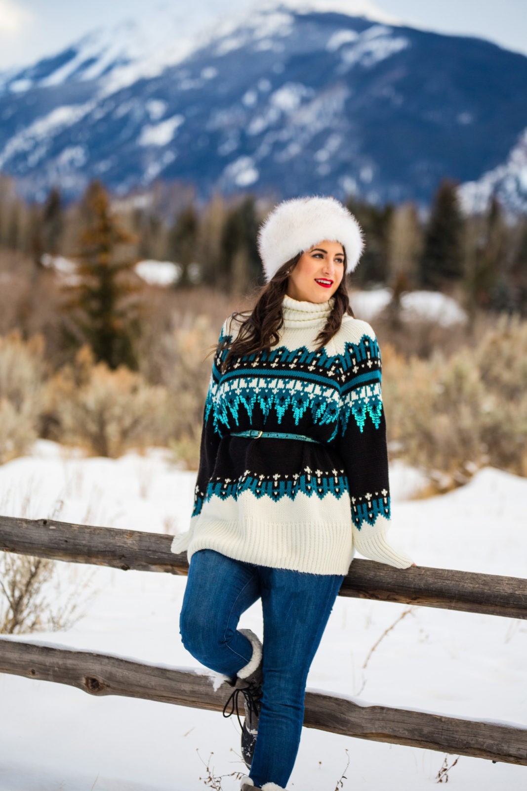 Ski Resort Style featured by top US fashion blogger Laura Lily; Image of a woman wearing Topshop Sweater, Mott & Bow Jeans, Sorel boots, NOAKE hat and Aldo sunglasses.