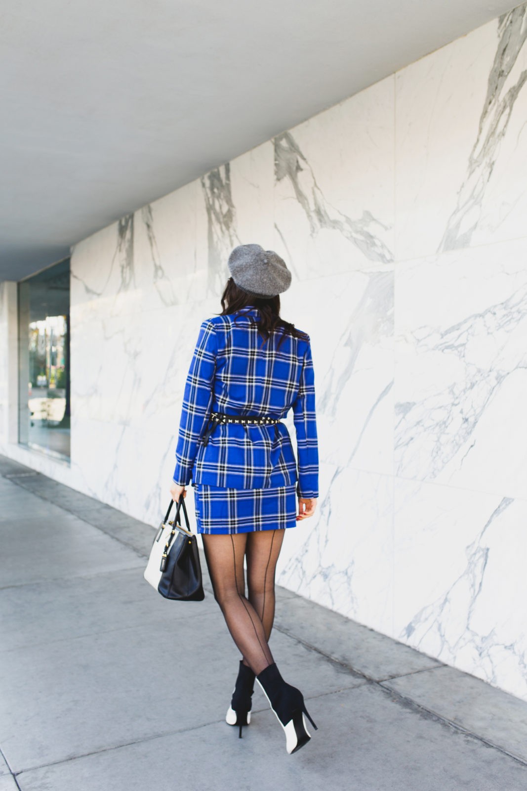 Blue plaid suit style for Spring by top US fashion blogger, Laura Lily: image of a woman wearing an ASOS blue plaid suit, Wolford back seam tights, Dynamic Asia hat, Steve Madden black and white booties, 