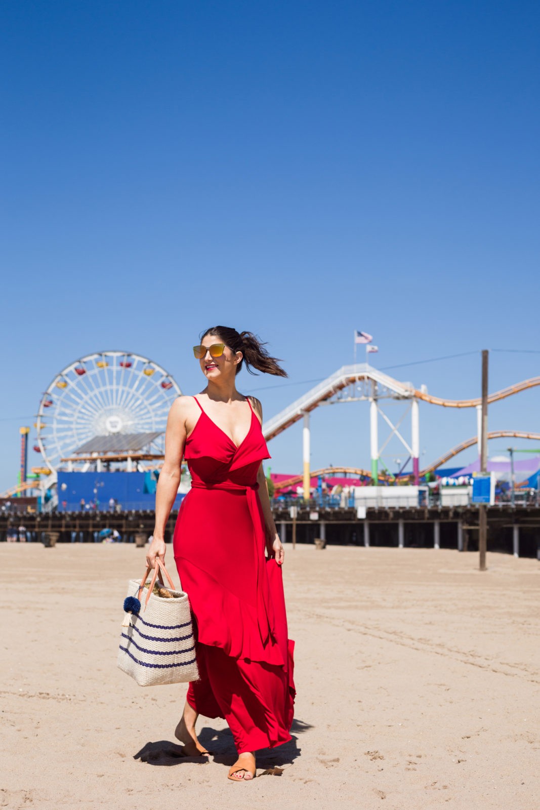 How to Take the Best Travel Photos ,Summer Dresses Under 50, Summer Fashion Trends Walmart We Dress America by Fashion Blogger Laura Lily | How to Take Good Travel Photos by popular California travel blogger, Laura Lily: image of a woman walking down the beach by the Santa Monica Pier. 