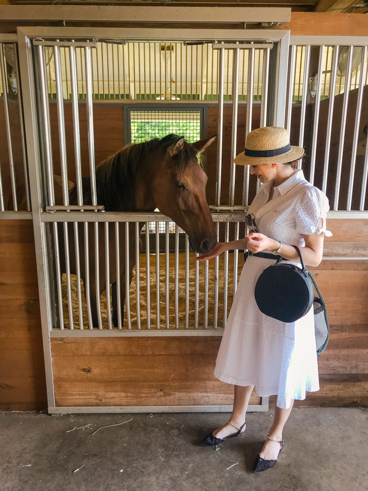 Montage Palmetto Bluff Resort Review by Luxury Travel Blogger Laura Lily: image of a woman feeding a horse in the Palmetto Bluff Resort Longfield stables. 