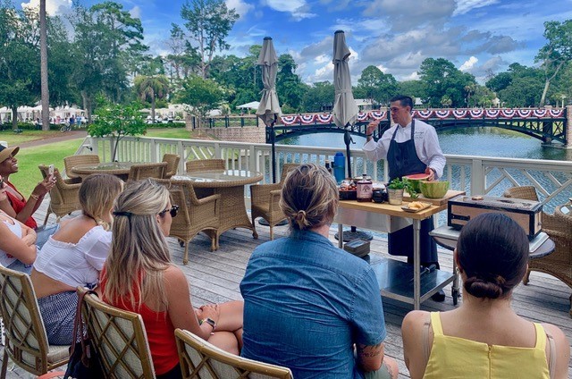 Montage Palmetto Bluff Resort Review by Luxury Travel Blogger Laura Lily: image of a woman in a yellow dress sitting outside at a cooking class.