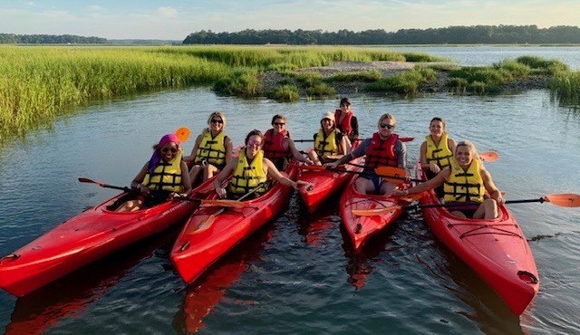 Montage Palmetto Bluff Resort Review by Luxury Travel Blogger Laura Lily: image of a multiple people next to each other in red kayaks. 