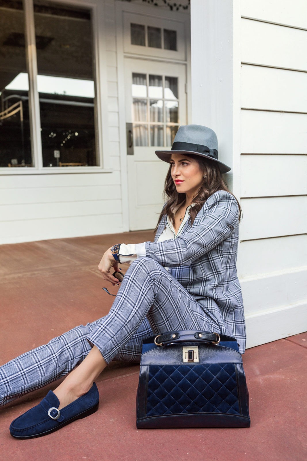 Borrowed from the Boys: Menswear Outfit Ideas for Ladies by Fashion Blogger Laura Lily | Borrowed from the Boys: Menswear for Women by popular California blogger, Laura Lily: image of woman standing outside and wearing a blue plaid suite, blue fedora hat, and Sas blue suede loafers. 