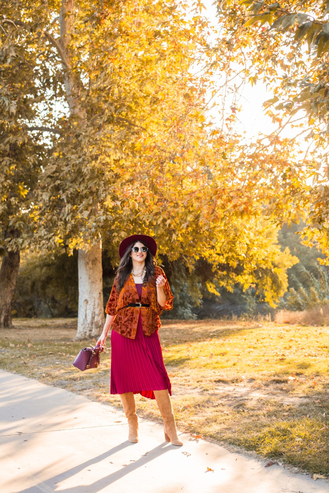 What to wear to meet the parents by LA Fashion Blogger Laura Lily: image of a woman outside wearing a Target A New Day Women's Velvet Kimono, Nordstrom Sam Edelman Caprice Knee-High Boot, Target A New Day Women's Relaxed Fit High-Rise Pleated Skirt, and holding a Senreve Midi Maestra bag. 