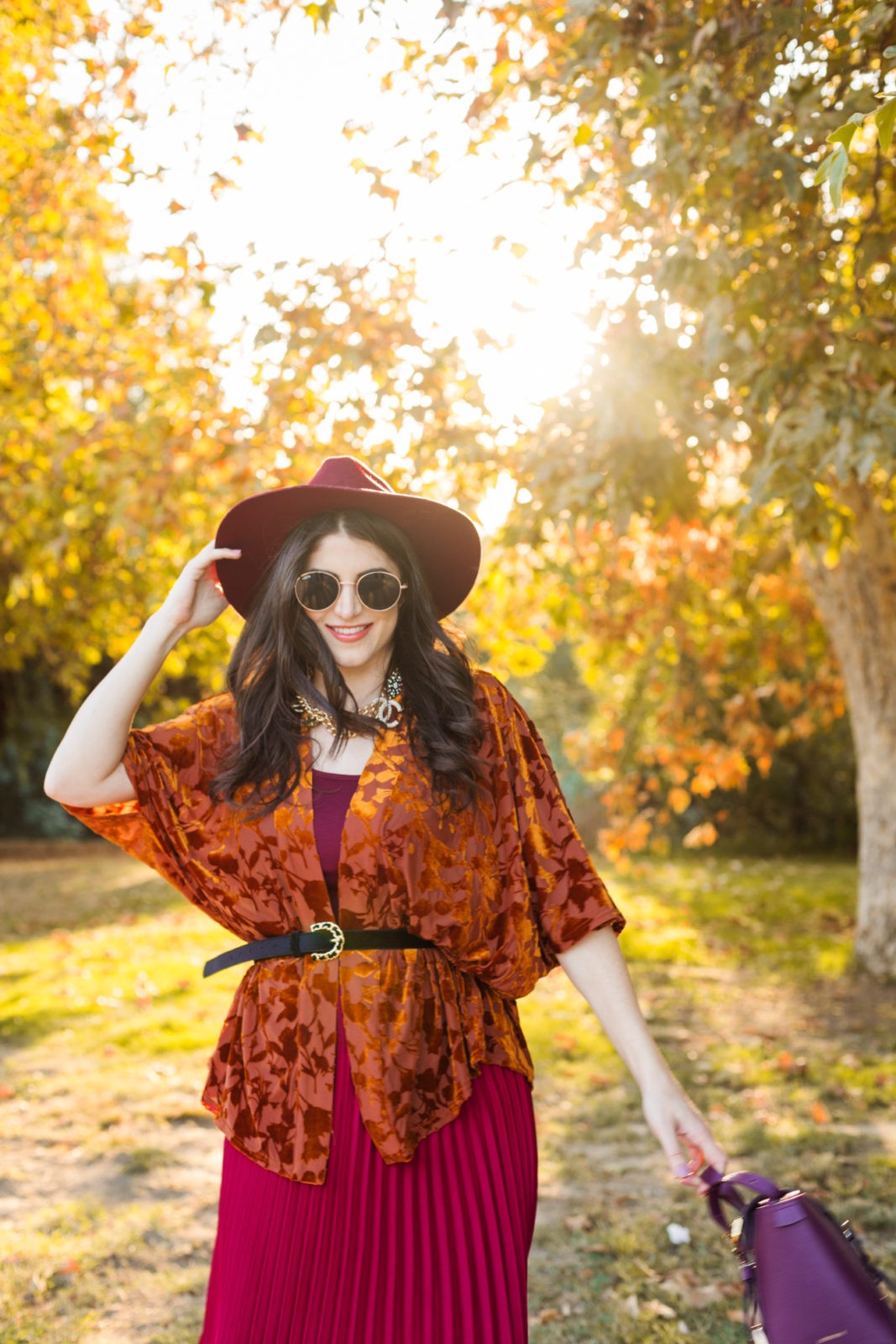 What to wear to meet the parents by LA Fashion Blogger Laura Lily: image of a woman outside wearing a Target A New Day Women's Velvet Kimono, Nordstrom Sam Edelman Caprice Knee-High Boot, Target A New Day Women's Relaxed Fit High-Rise Pleated Skirt, and holding a Senreve Midi Maestra bag. 