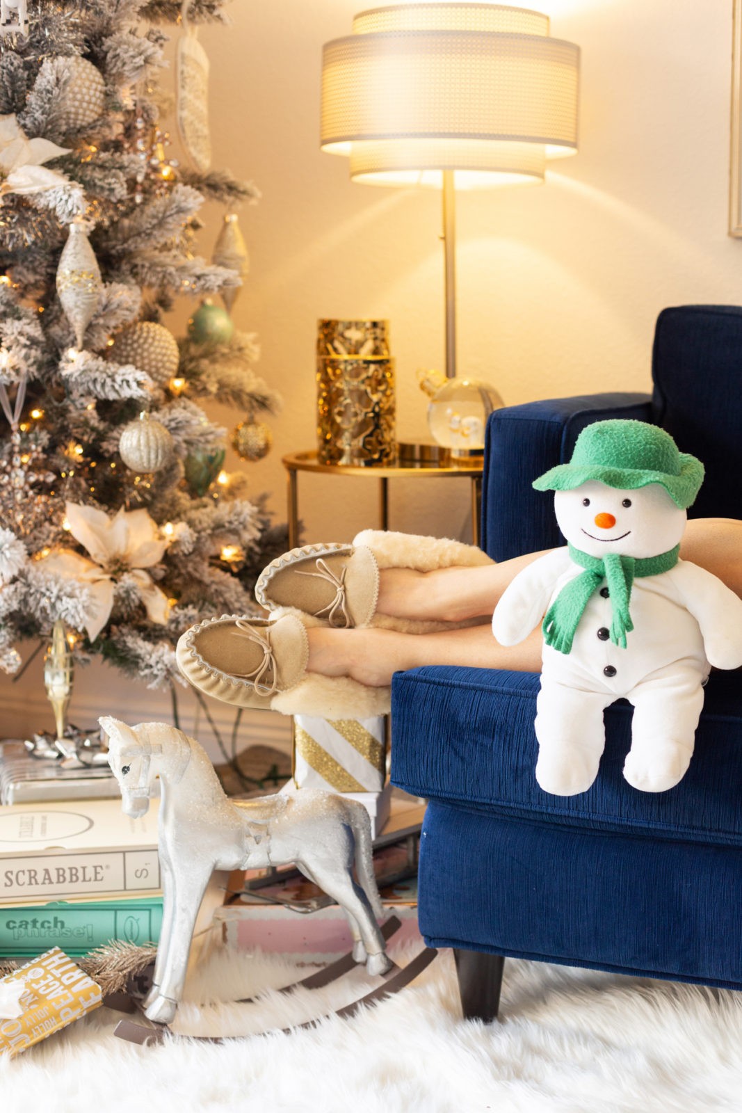 Gift Ideas for the Woman Who Has Everything by Lifestyle Blogger Laura Lily, Celtic & Co Shearling Sheep Slippers, Luxurious Gift Ideas for Her | Gift Ideas for the Woman Who Has Everything by popular Los Angeles life and style blogger, Laura Lily: image of a stuffed snowman sitting on a blue ottoman. 