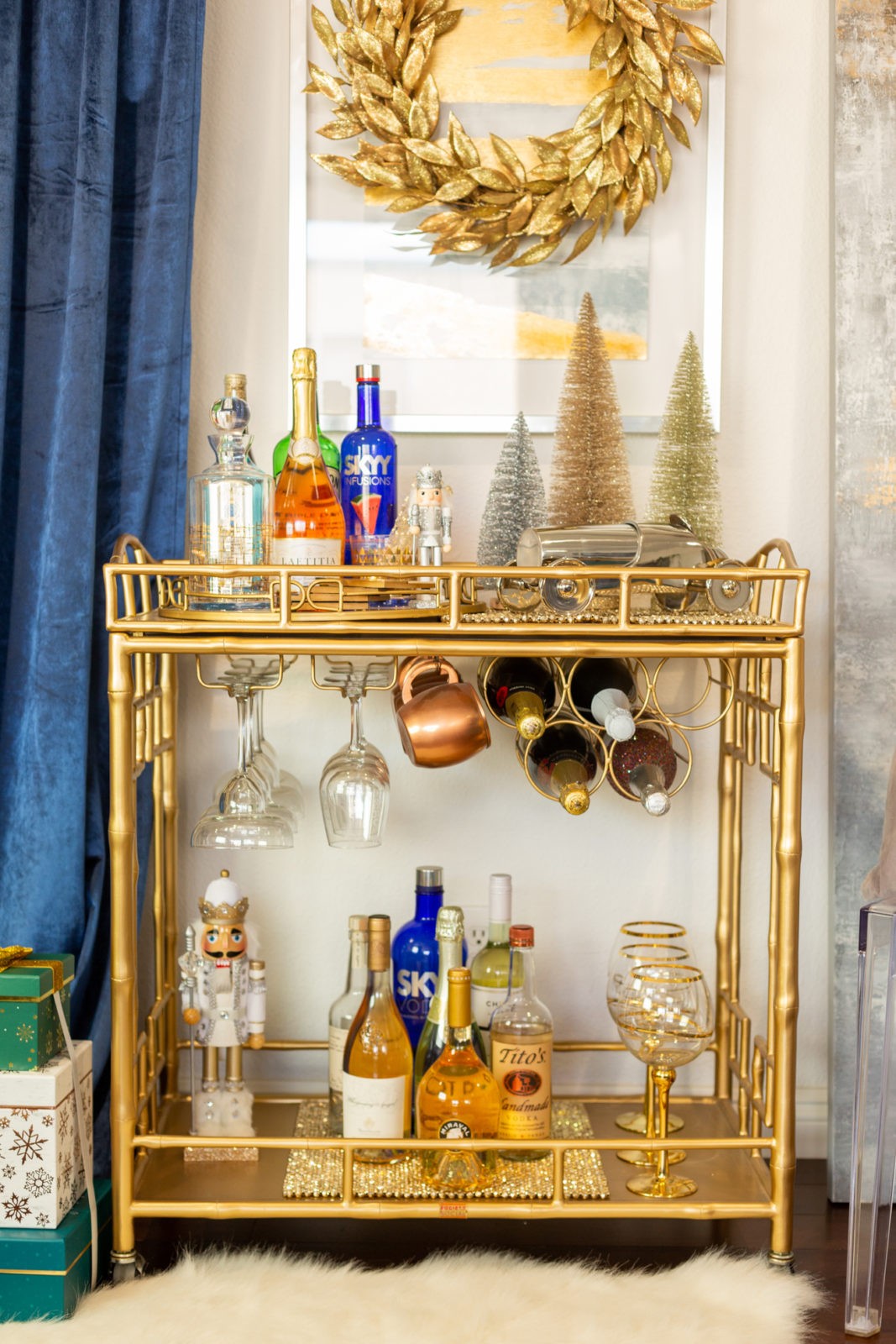 How to Decorate a Holiday Bar Cart in 5 Simple Steps by Home Decor Blogger Laura Lily, | Holiday Home Decor 2019 by popular Los Angeles life and style blogger, Laura Lily: image of gold bar cart with bottle brush metallic trees, glasses, a nutcracker, and alcoholic beverages. 
