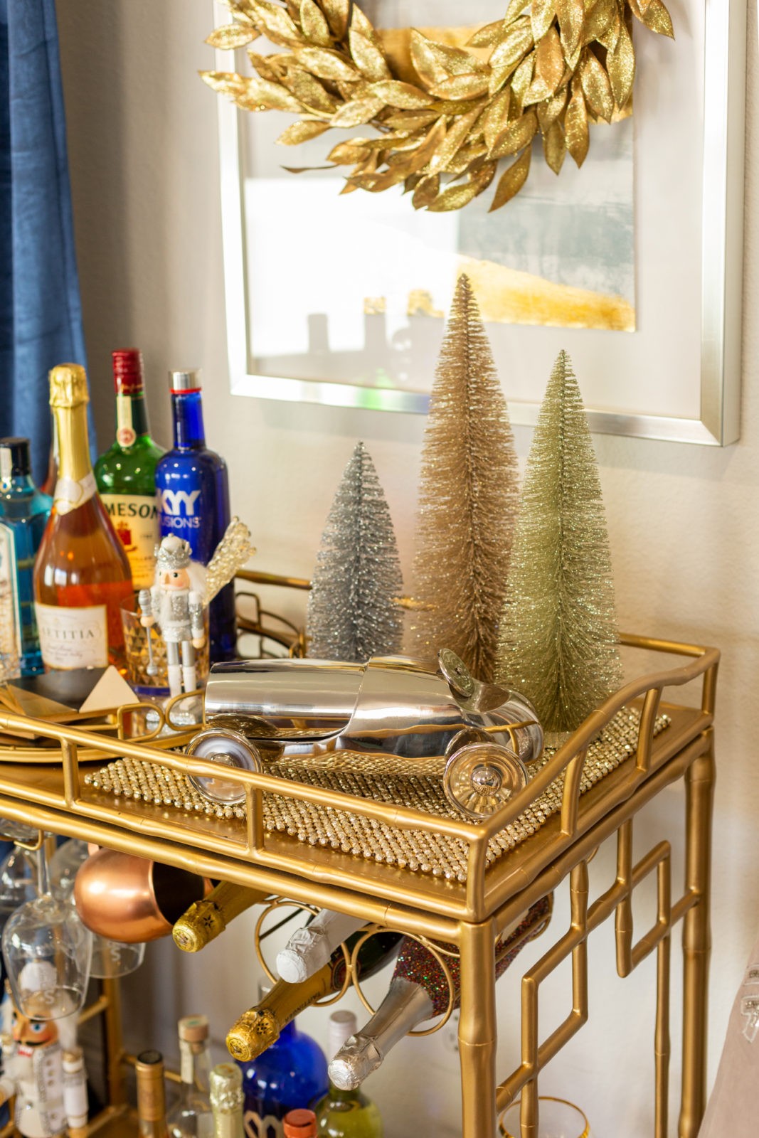 How to Decorate a Holiday Bar Cart in 5 Simple Steps by Home Decor Blogger Laura Lily | How to Decorate a Holiday Bar Cart in 5 Simple Steps by popular Los Angeles life and style blogger, Laura Lily: image of a gold bar cart with various alcoholic drinks, glasses, and holiday decor.