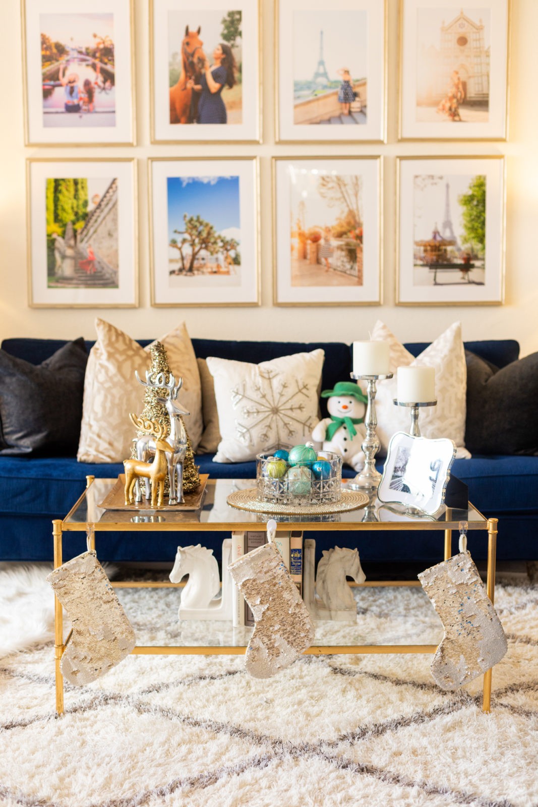 Holiday Home Decor by Home Decor Blogger Laura Lily | Holiday Home Decor 2019 by popular Los Angeles life and style blogger, Laura Lily: image of a living room decorated with Home Goods horse book ends and candle sticks, Target sequin stockings, RugsUSA rug,  Framebridge picture frames, Target and Z Gallerie throw pillows and Safavieh Aslan Antique Gold Leaf Coffee Table.