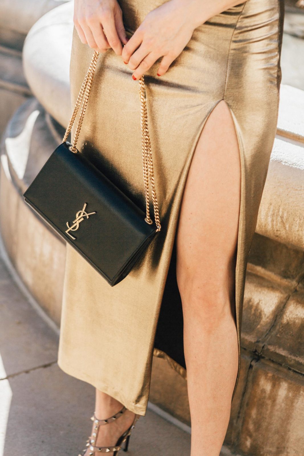 The Ultimate Holiday Outfit Guide by Fashion Blogger Laura Lily, Gold metallic dress | The Ultimate Glam Holiday Outfits Guide by popular Los Angeles fashion blogger, Laura Lily: image of a woman wearing a gold metallic dress and holding a Saint Laurent bag. 