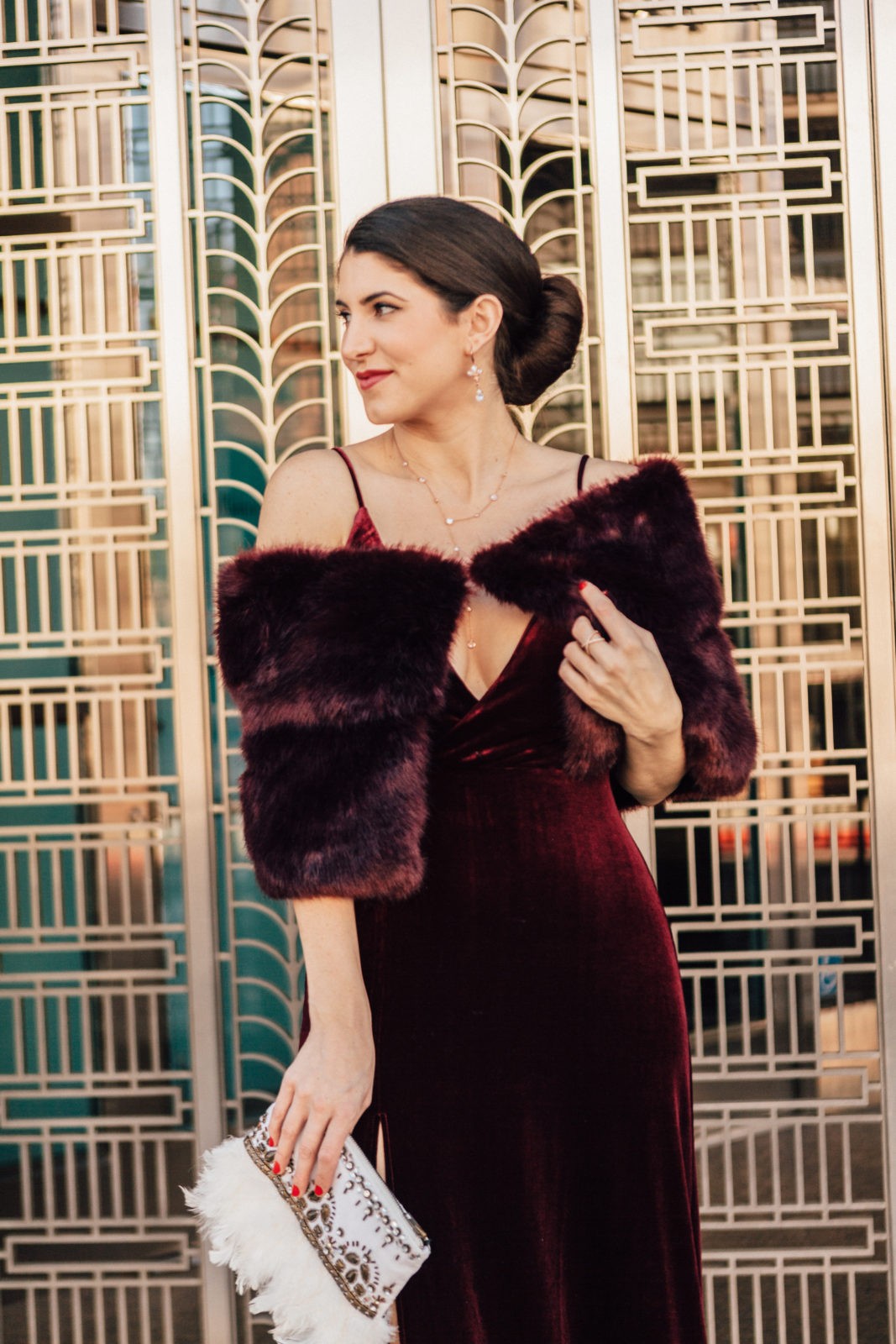 The Ultimate Holiday Outfit Guide by Fashion Blogger Laura Lily, red burgundy velvet dress | The Ultimate Glam Holiday Outfits Guide by popular Los Angeles fashion blogger, Laura Lily: image of a woman wearing a red velvet dress and red faux fur shawl. 